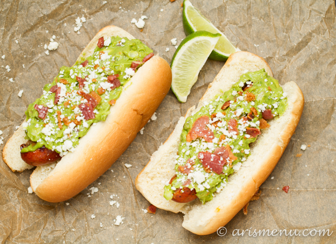Spicy Bacon Guacamole Dogs: Spicy grilled hot dogs smothered with roasted jalapeno & garlic bacon guacamole + cotija cheese